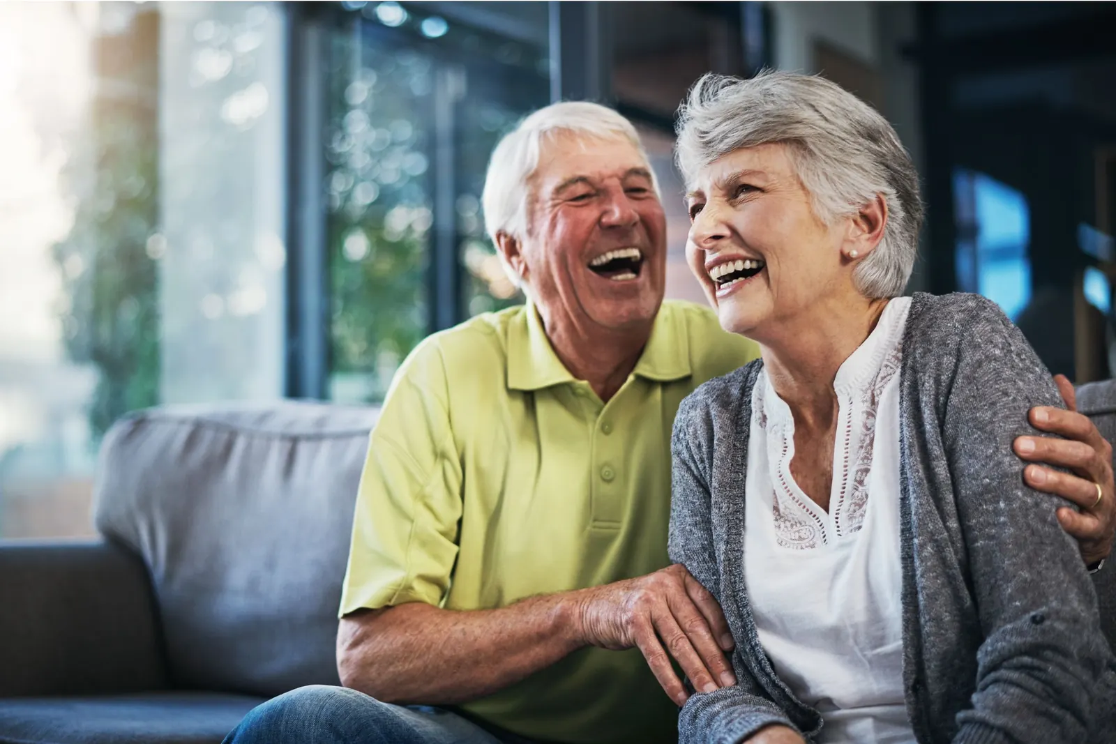 An older couple laughing together at home